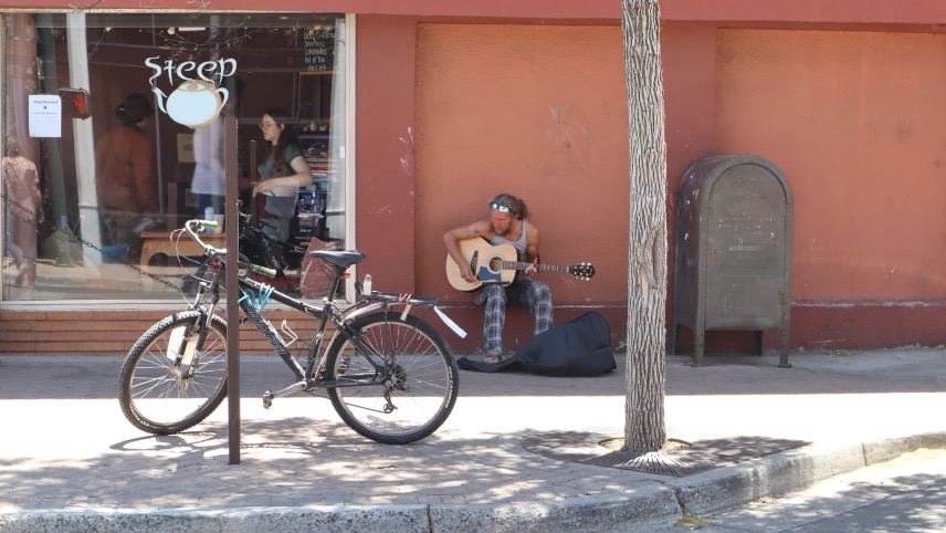 A Flagstaff street singer sings along as he strums his guitar.