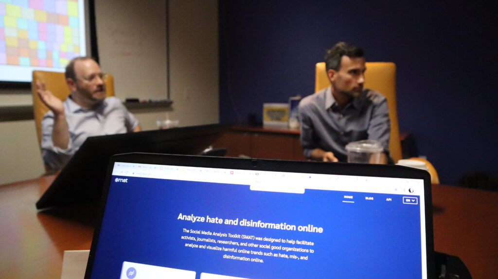 ASU's Michale Simeone and Shawn Walker talk to the scholars, with the Social Media Analysis Toolkit website in the foreground