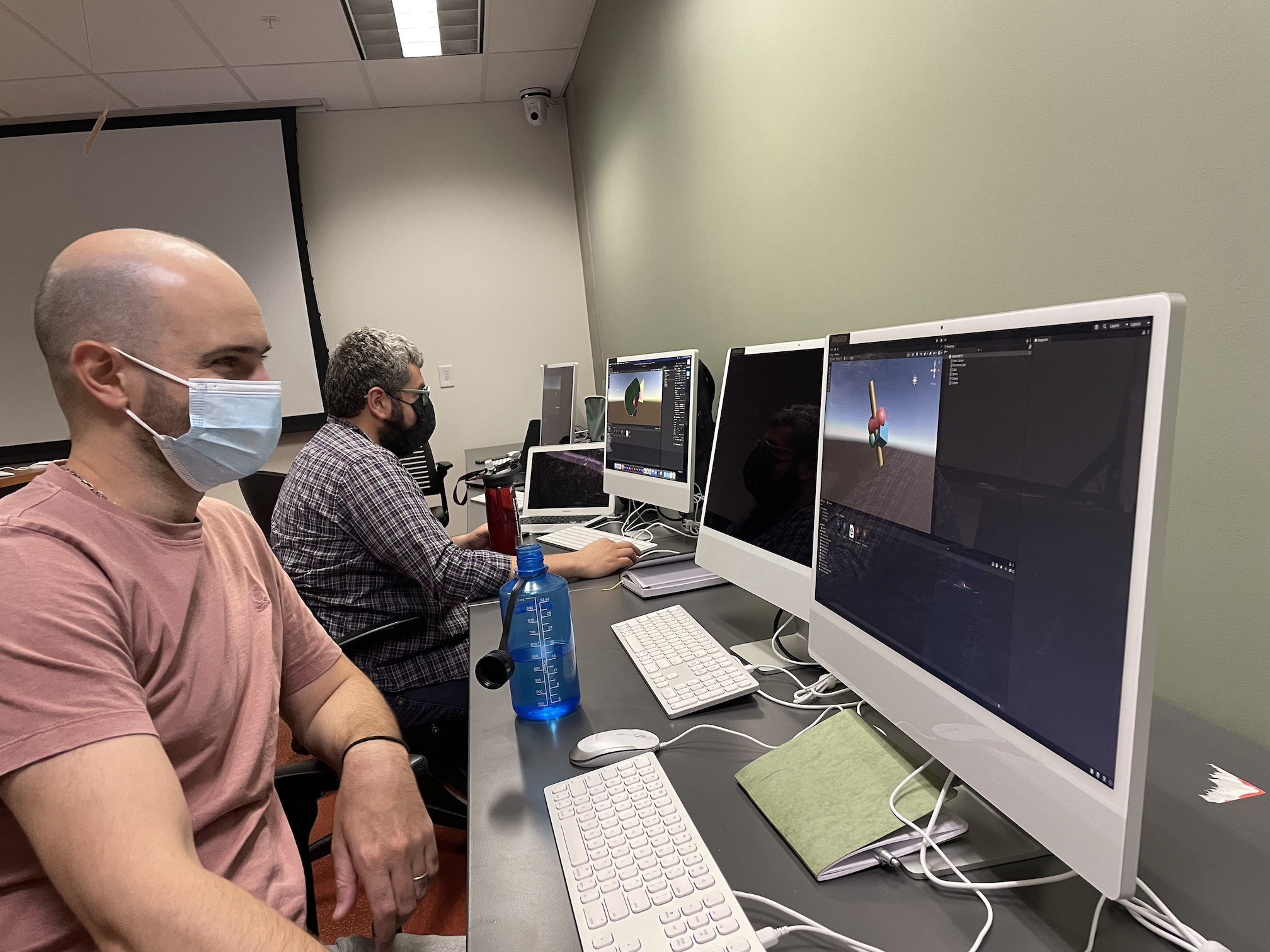 Two scholars sit in a Cronkite School computer lab, creating immersive environments