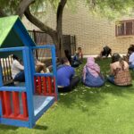 The scholars seated in a play area at the CASS Vista Colina shelter facility, as they discuss the concept of "home"