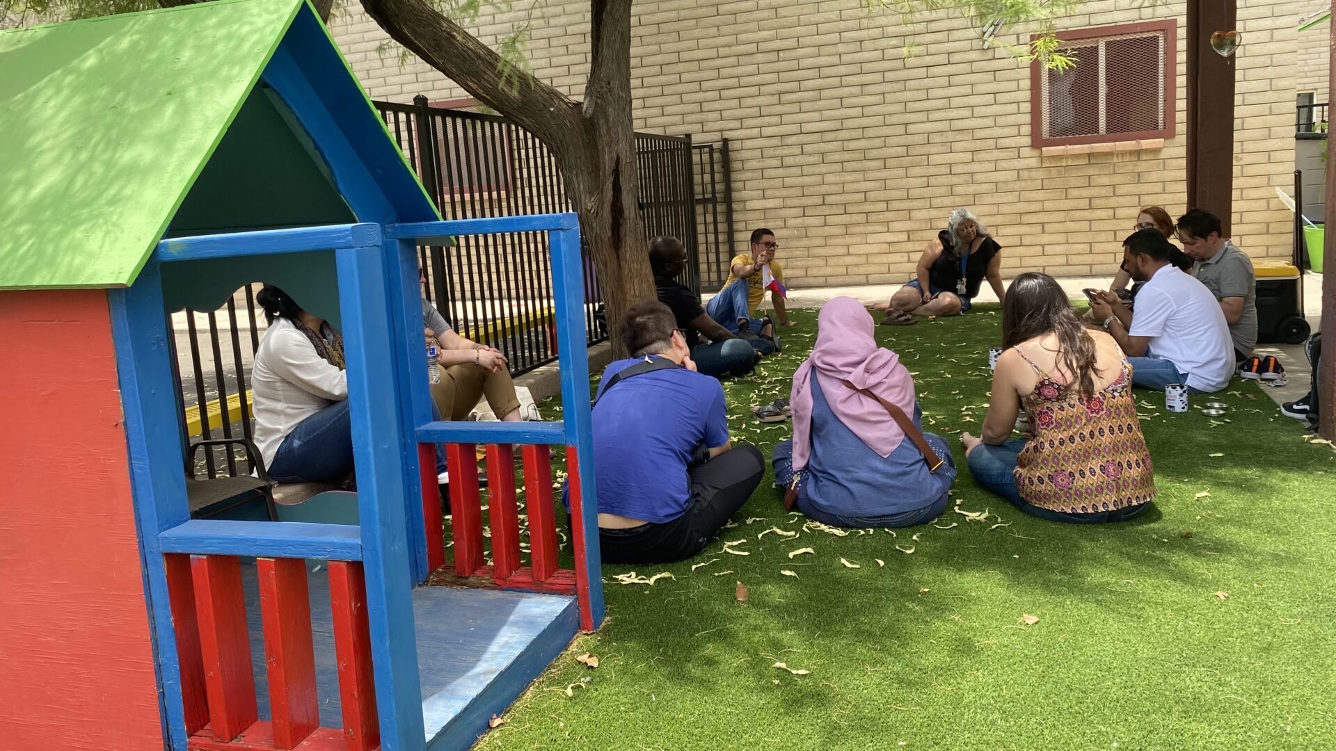 The scholars seated in a play area at the CASS Vista Colina shelter facility, as they discuss the concept of "home"