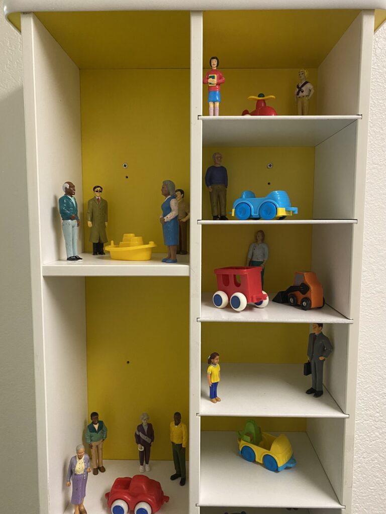 A shelf of toy people and cars