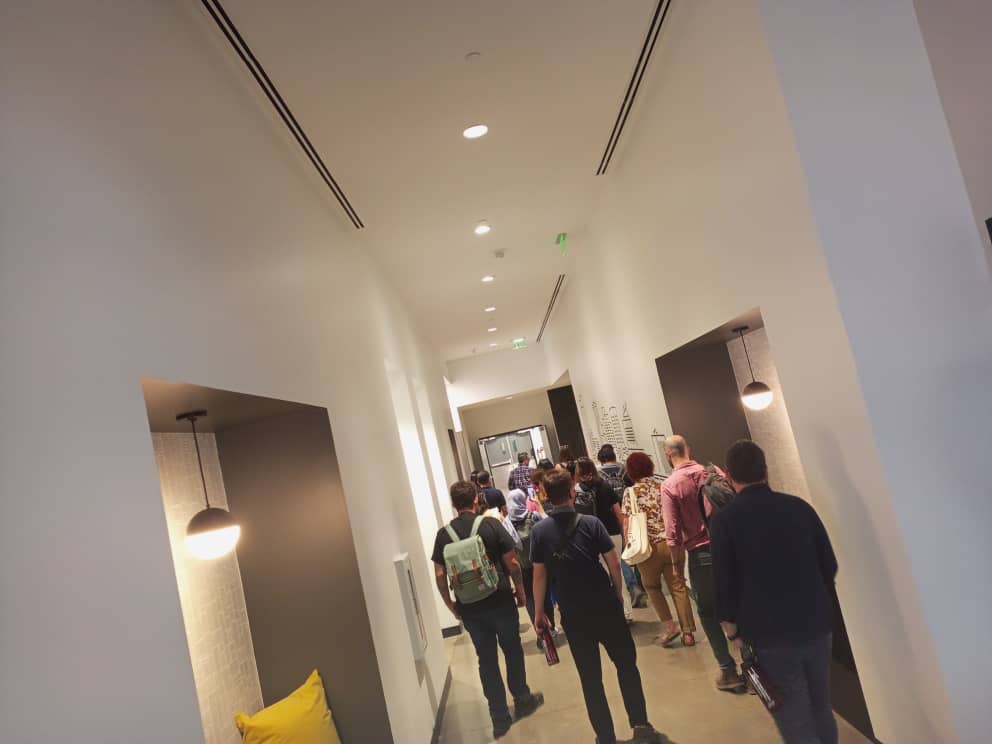 The scholars walk together down a corridor of learning