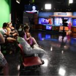 Scholars watch students rehearse the Cronkite News program