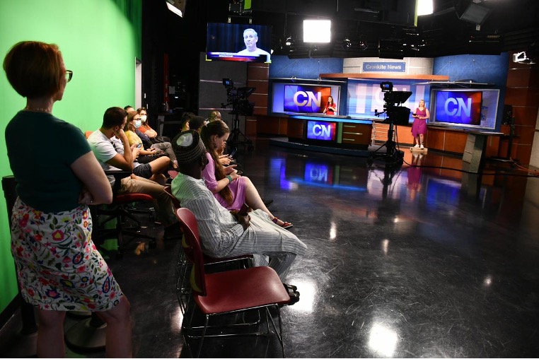 Scholars watch students rehearse the Cronkite News program