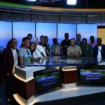 The scholars pose for a group photo behind the Arizona Midday anchor desk