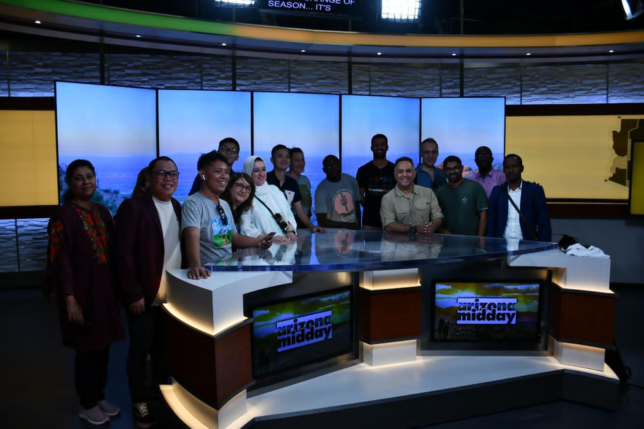 The scholars pose for a group photo behind the Arizona Midday anchor desk