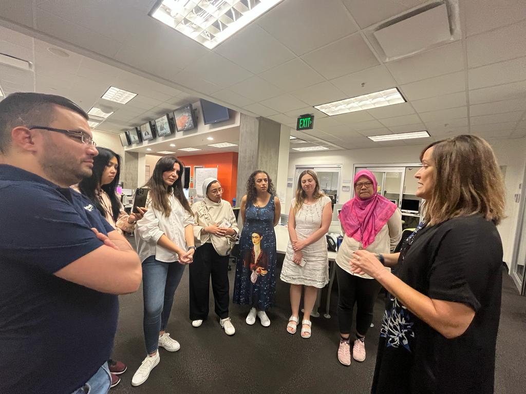 A group of scholars listen attentively to a Cronkite professor