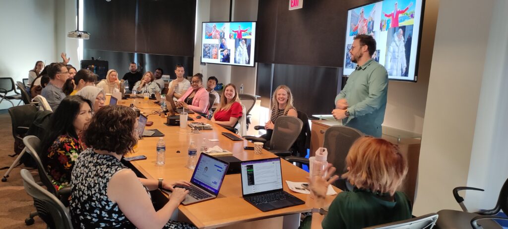 The scholars sitting around a conference table at GSI in Tempe while Dr. Joshua Garland shows AI-generated images