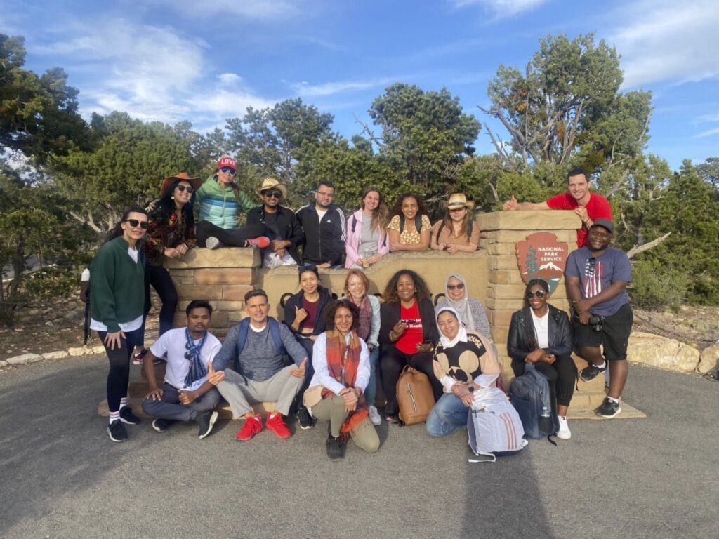 The Scholars pose for a group photo around the Grand Canyon park sign