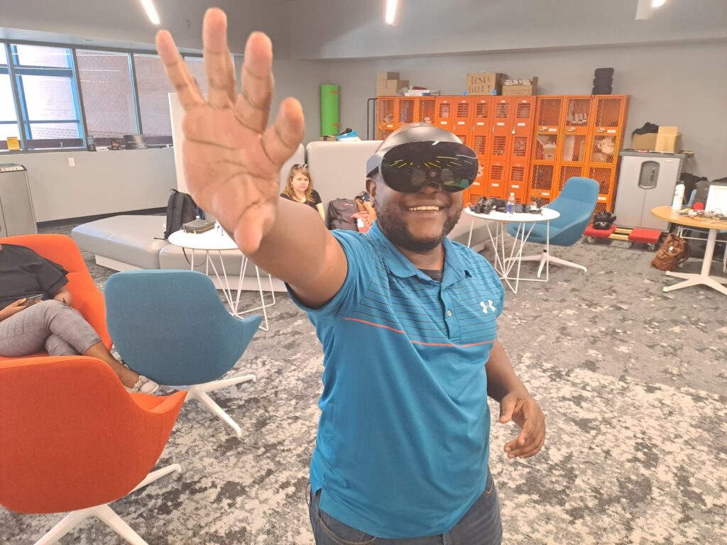 A man wearing virtual reality goggles reaches toward the camera