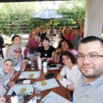 The scholars, program staff, and community members smile for one of their first group selfies