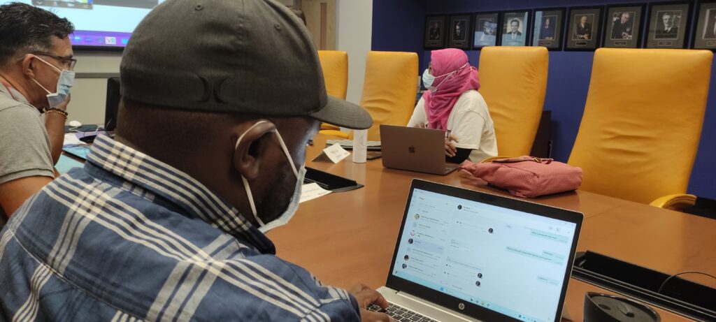 Scholars in Room 444; in the foreground, Elastus (Zambia) looks at his laptop screen