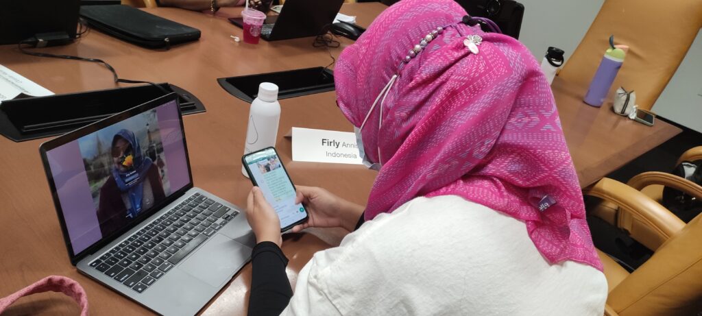 Firly Annisa of Indonesia looks at her phone and laptop screen during a media literacy session in Cronkite room 444