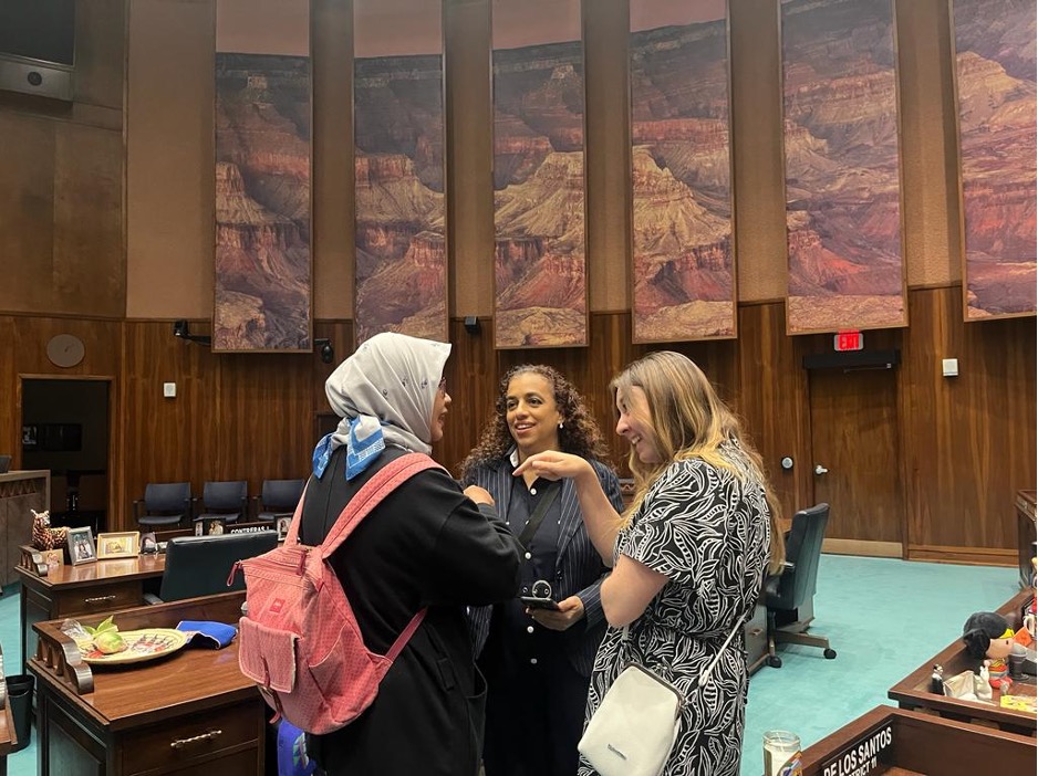 Three women scholars chatting in the Arizona State Legislature