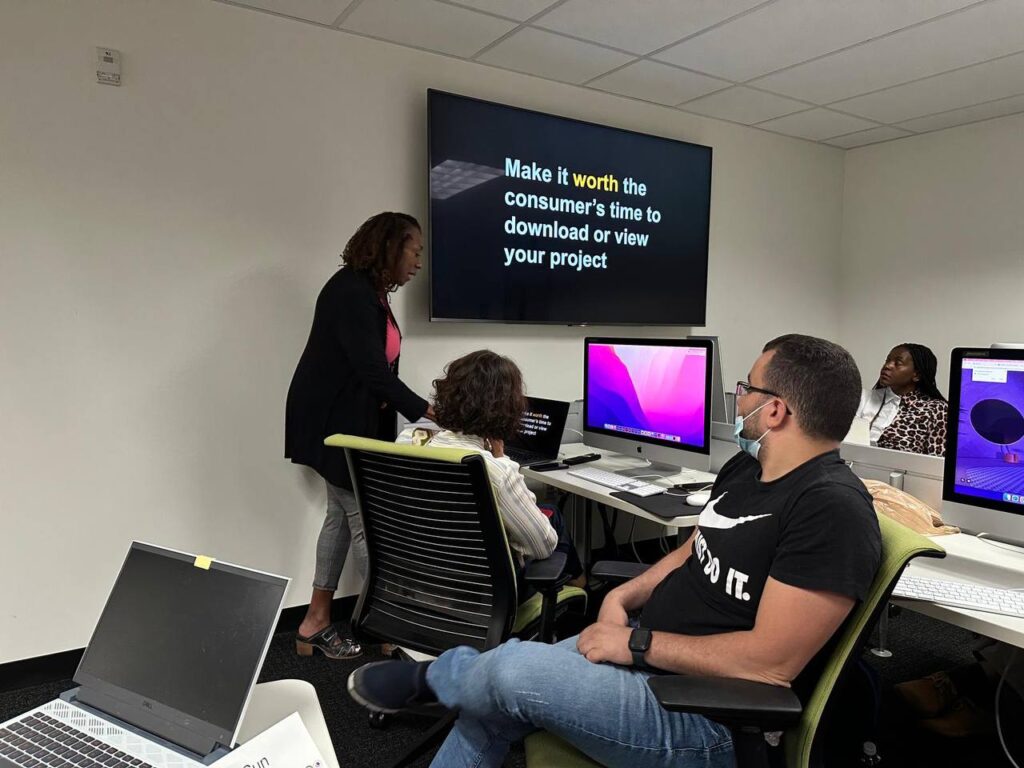 The scholars listen to Retha Hill lecture in front of a smart screen in a computer lab