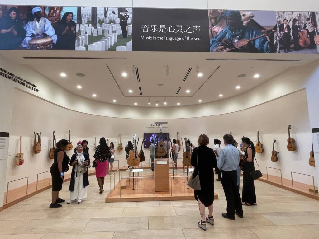 The scholars admire guitars from around the world on display at the MIM