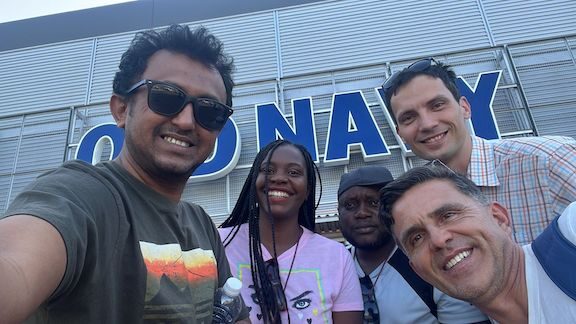 Scholars take a group selfie in front of an Old Navy story while shopping