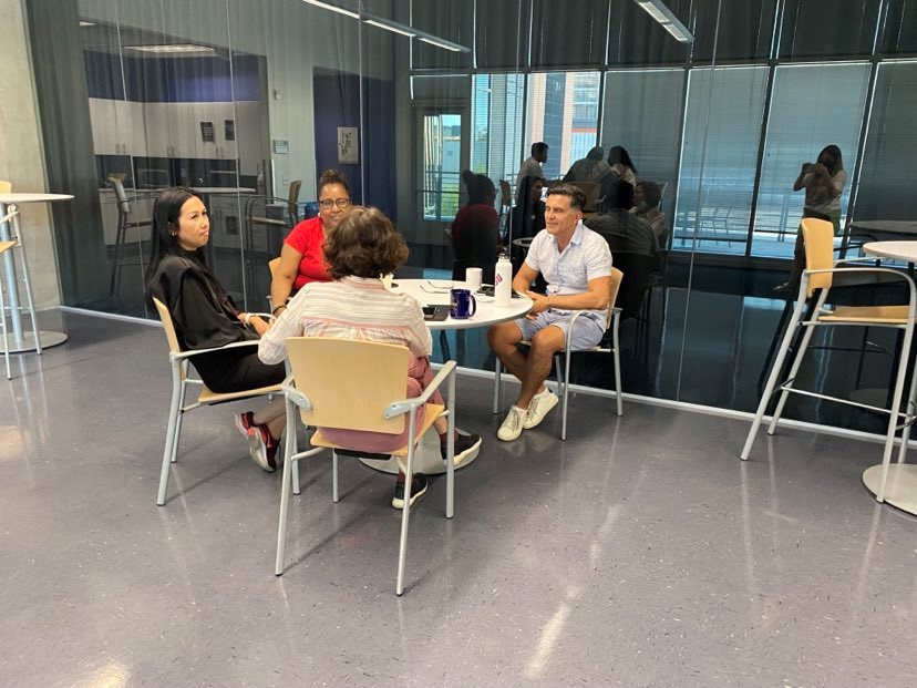 Four scholars sit around a small table for group work