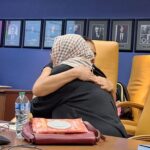 Two scholars embrace affectionately