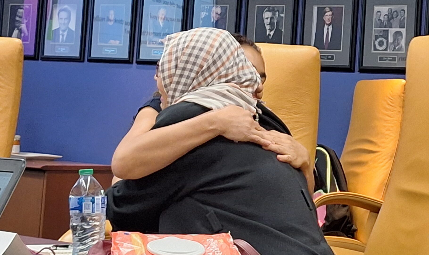 Two scholars embrace affectionately