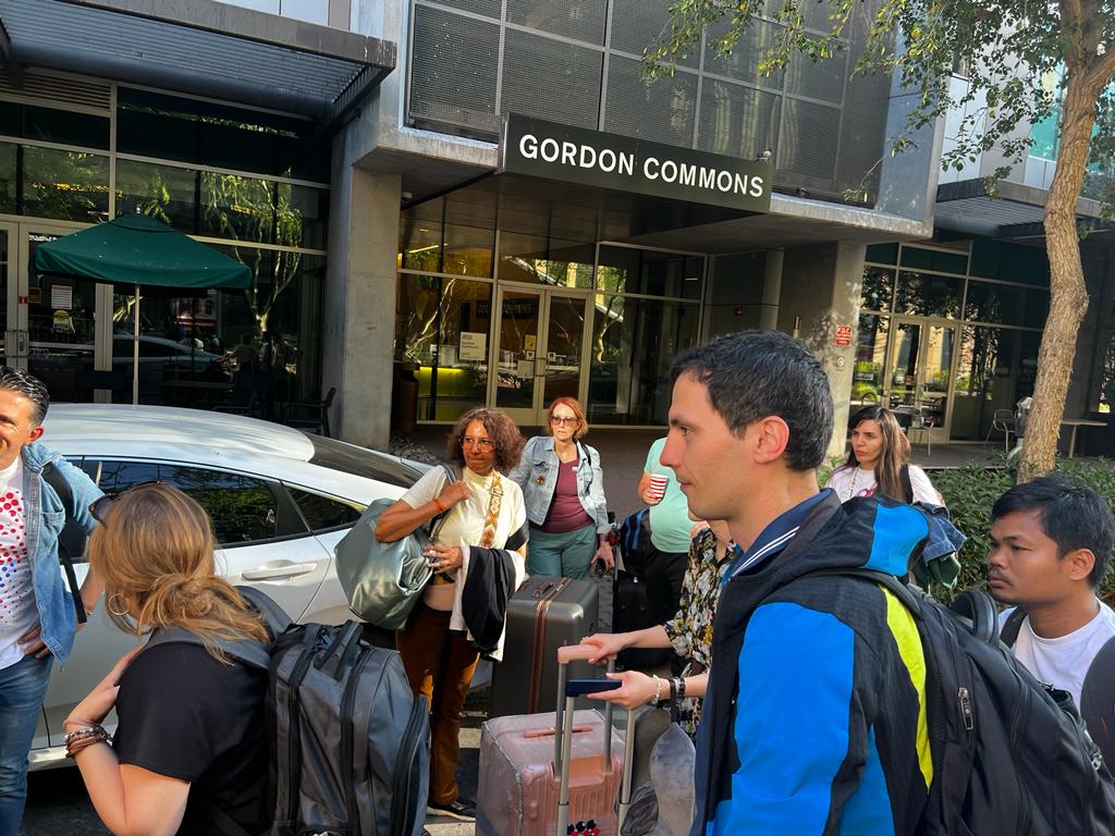 The Scholars prepare to load their luggage into transit vehicles in front of Gordon Commons