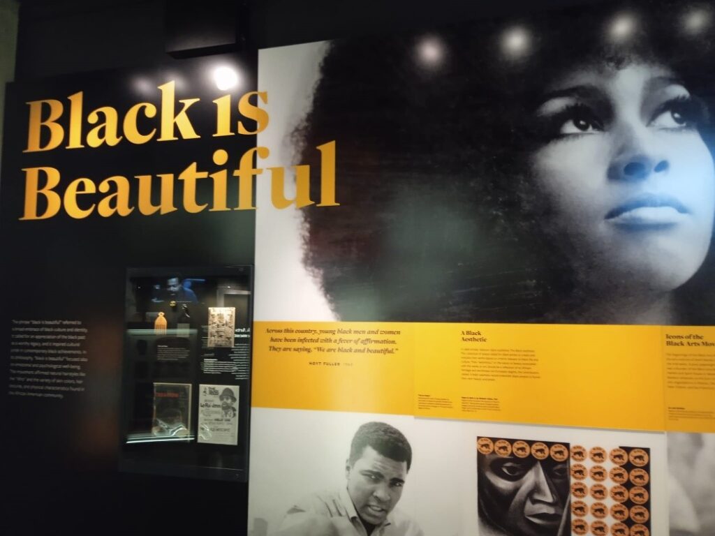 A wall with images of Black artists and the words "Black Is Beautiful"