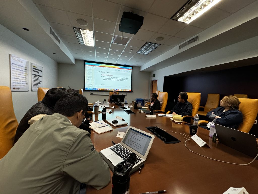 Dan Barr (center) lectures in front of a slide about the U.S. Constitution, with the scholars listening attentively from around the conference table in Cronkite room 444