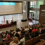 A legal lecture is well attended in a large, sunny, theatre-style event space