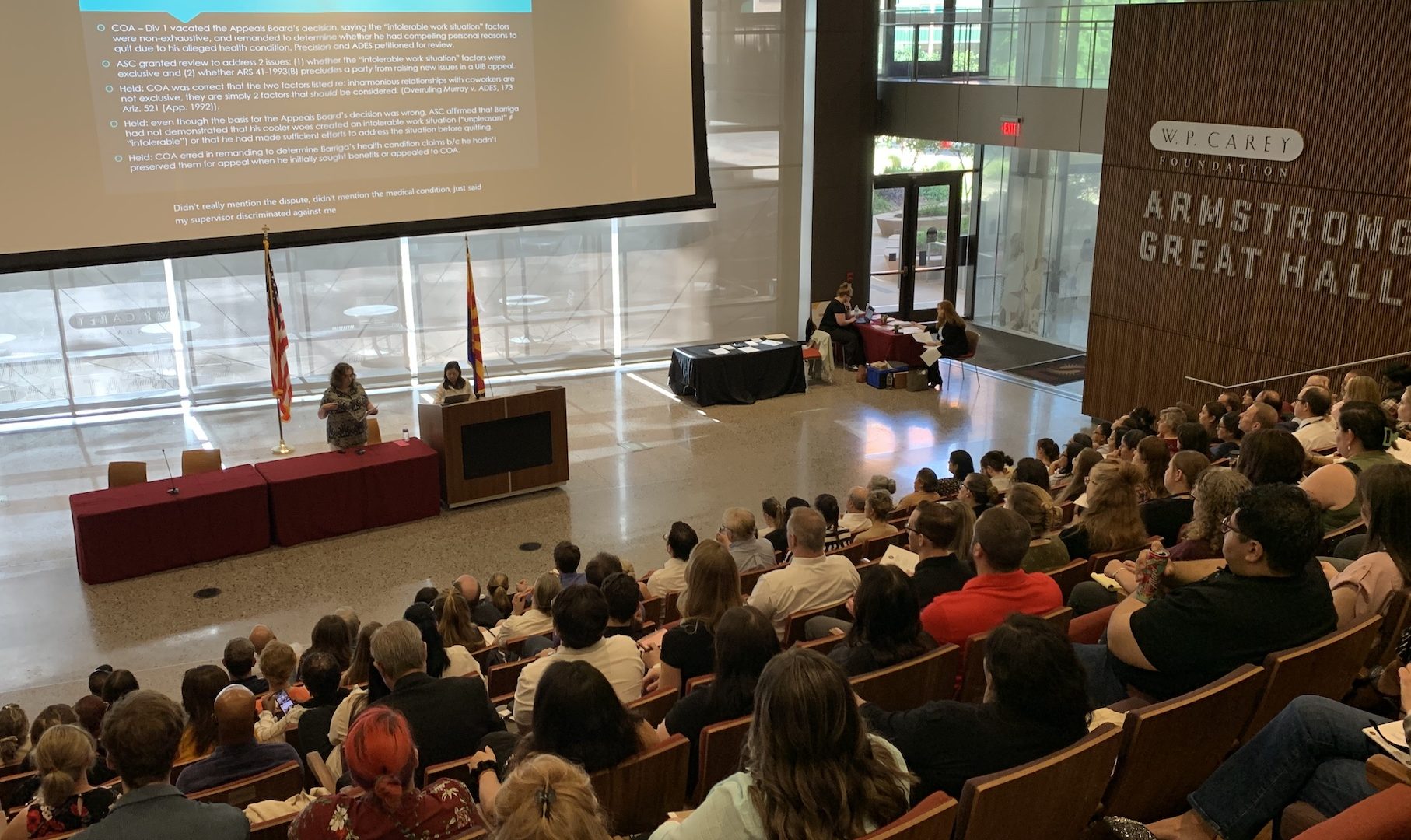 A legal lecture is well attended in a large, sunny, theatre-style event space