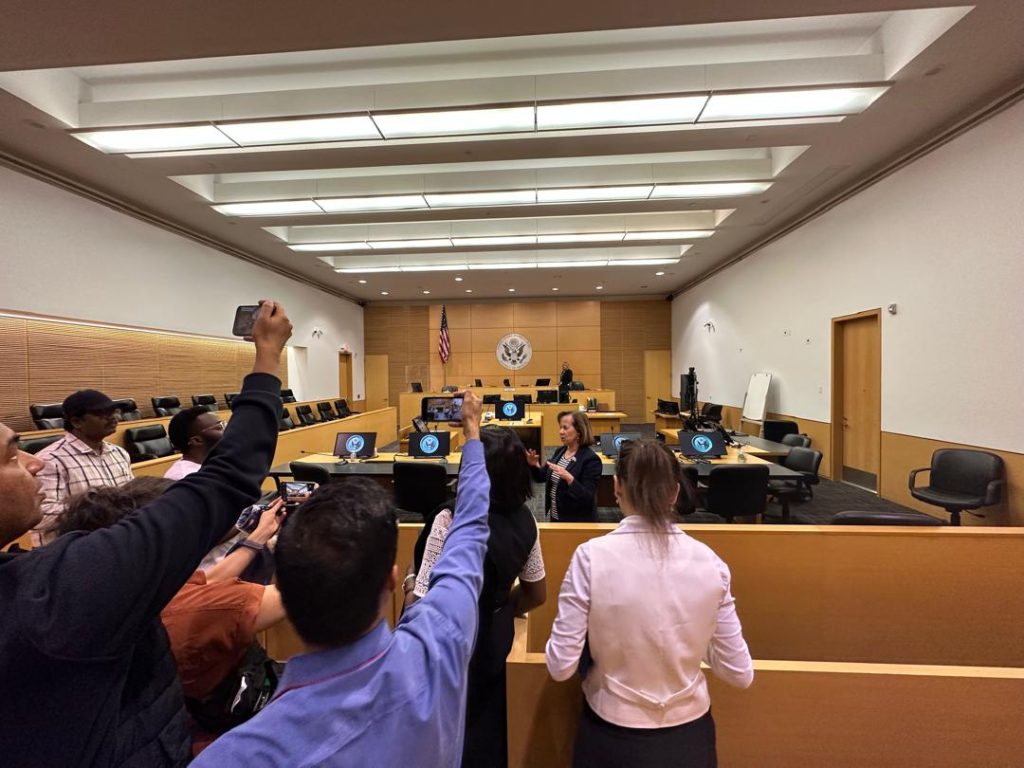 The scholars take selfies in the courtroom, on the right side of the law