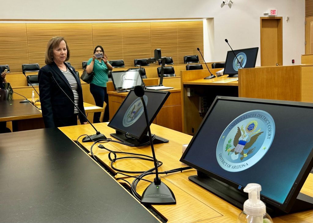 A view of a courtroom filled with monitors bearing the US District Court seal