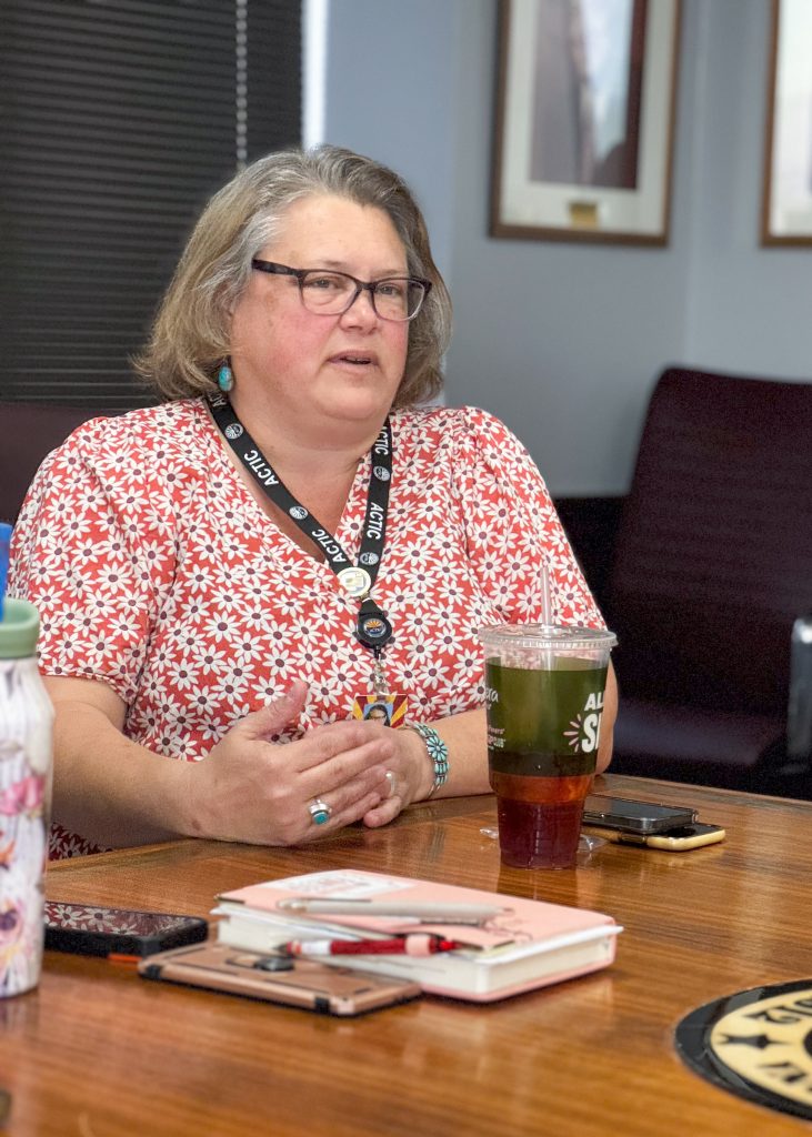 A woman explains Arizona's complex information across a table