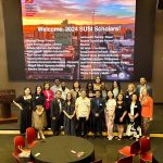 The scholars pose in the First Amendment Forum of the Cronkite School set up for their Welcome Reception